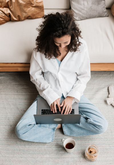 Woman sitting on the floor working on laptop
