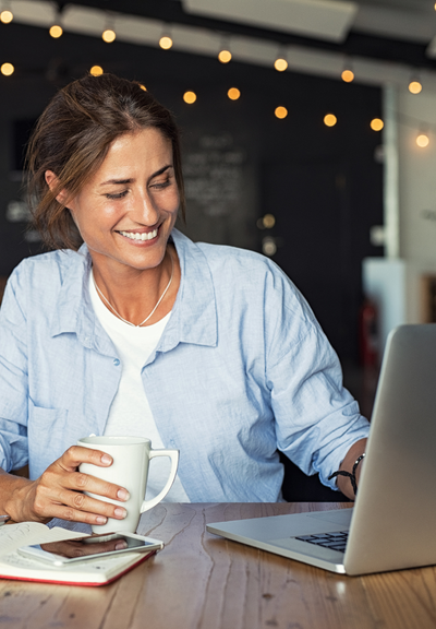 Woman sitting at computer with coffee Woman sitting at computer with coffee